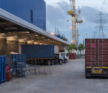 Truck is carrying container parking in front warehouse